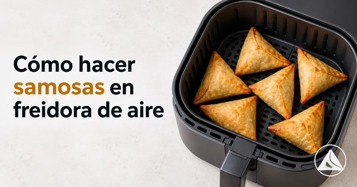 Samosas colocadas en la cesta de una freidora de aire para cocinarlas hasta que queden crujientes